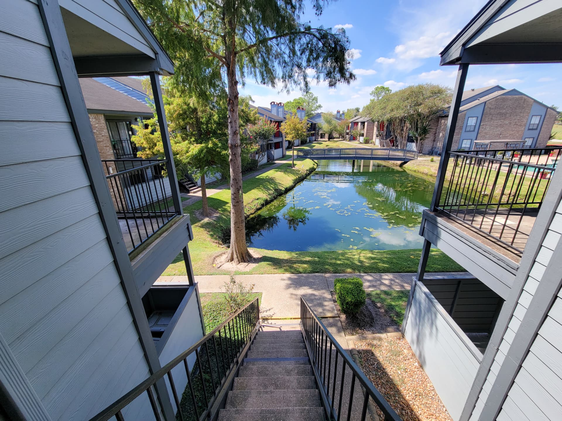 Courtyard pond with footbridge framed by resident balconies